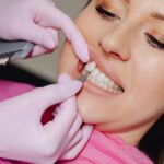 Close-up of a dentist showing dental veneers and discussing dental veneers cost