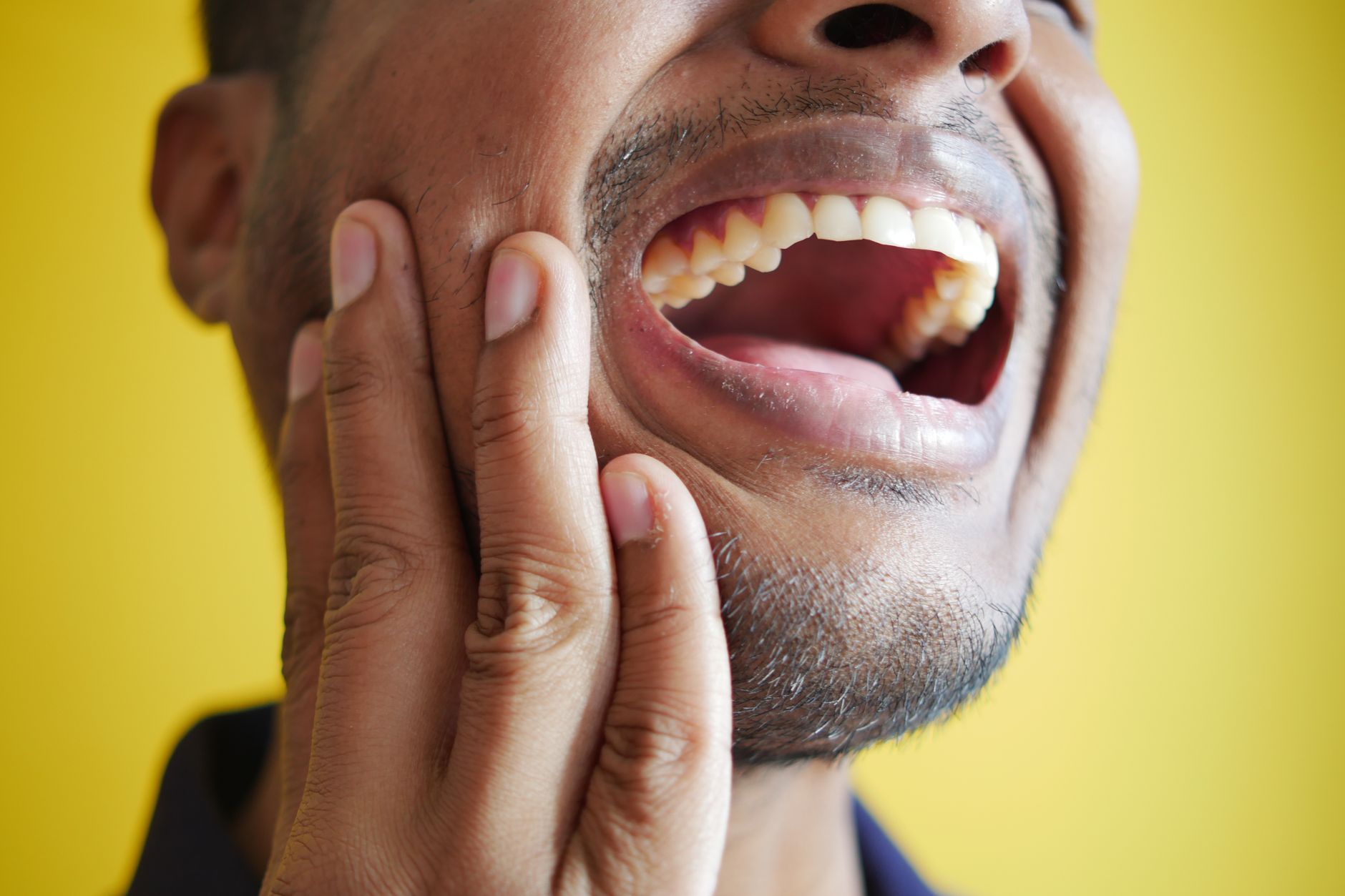 Person holding a knocked out tooth in a tissue, showing what to do when a knocked out tooth occurs